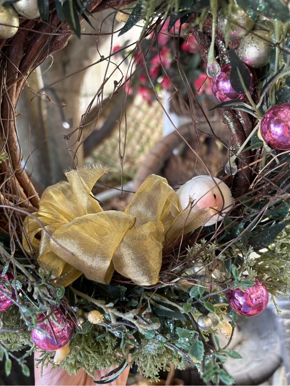 Decorative Holiday Wreath with Pink Ornaments and Gold Bow